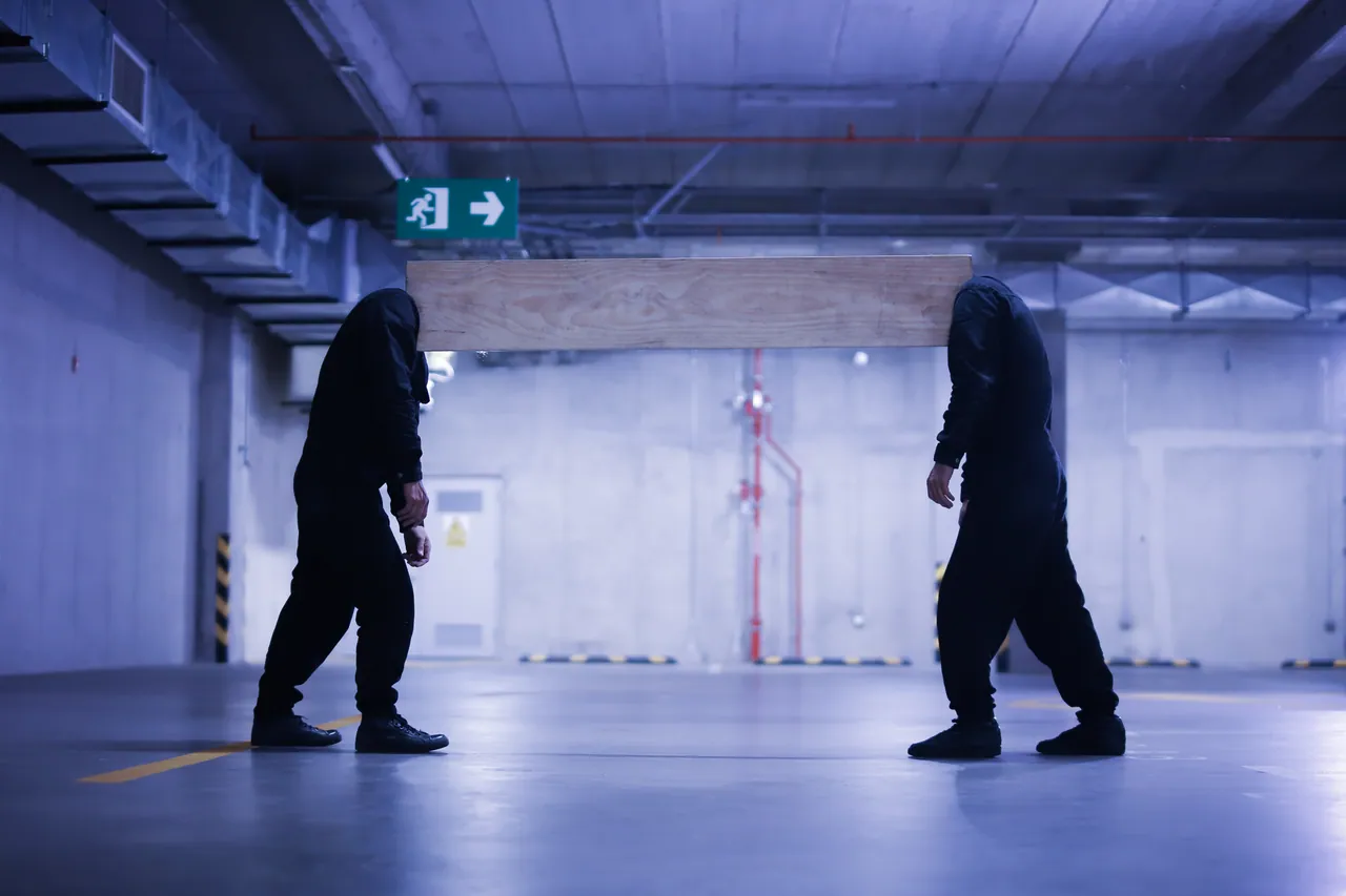 Two figures part ways in a parking garage, Los Innato series