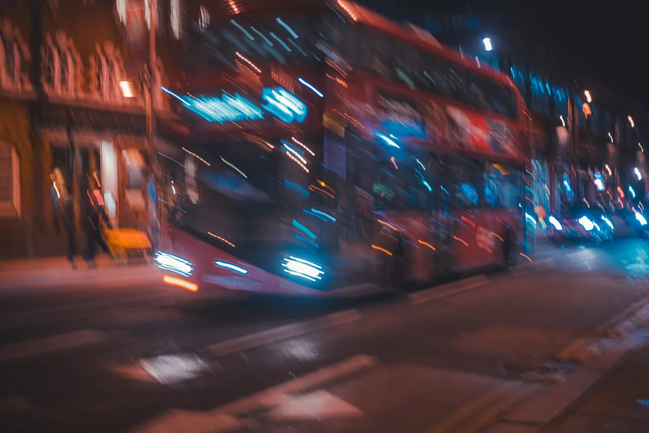 Bus rojo pasando de noche