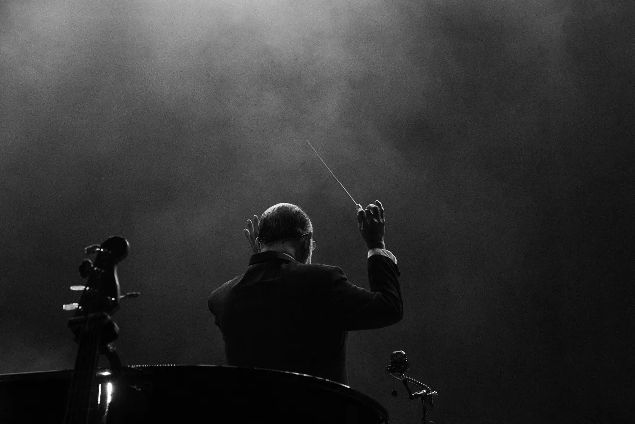 Director de orquesta a contraluz, concierto de Jacob Collier