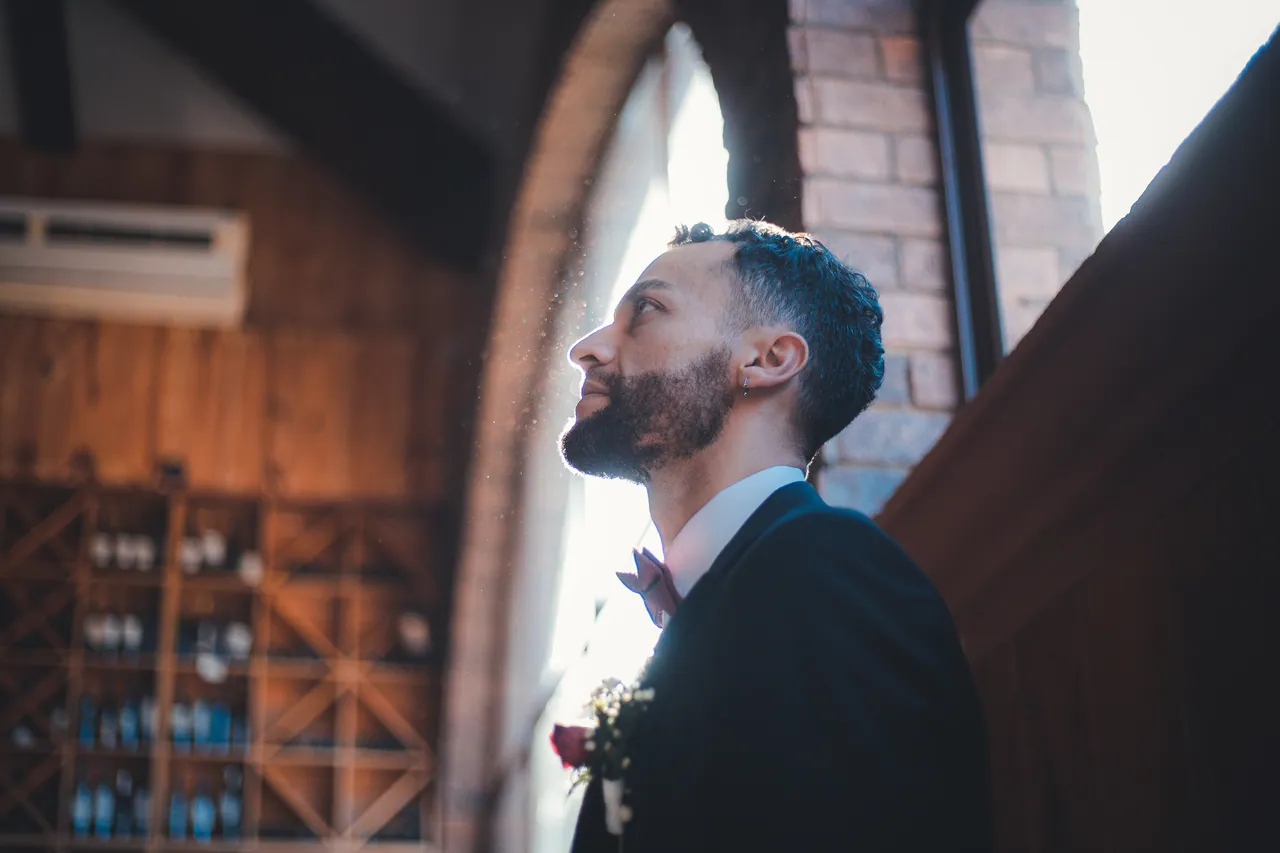 Hombre de traje con luz de ventana, día de boda
